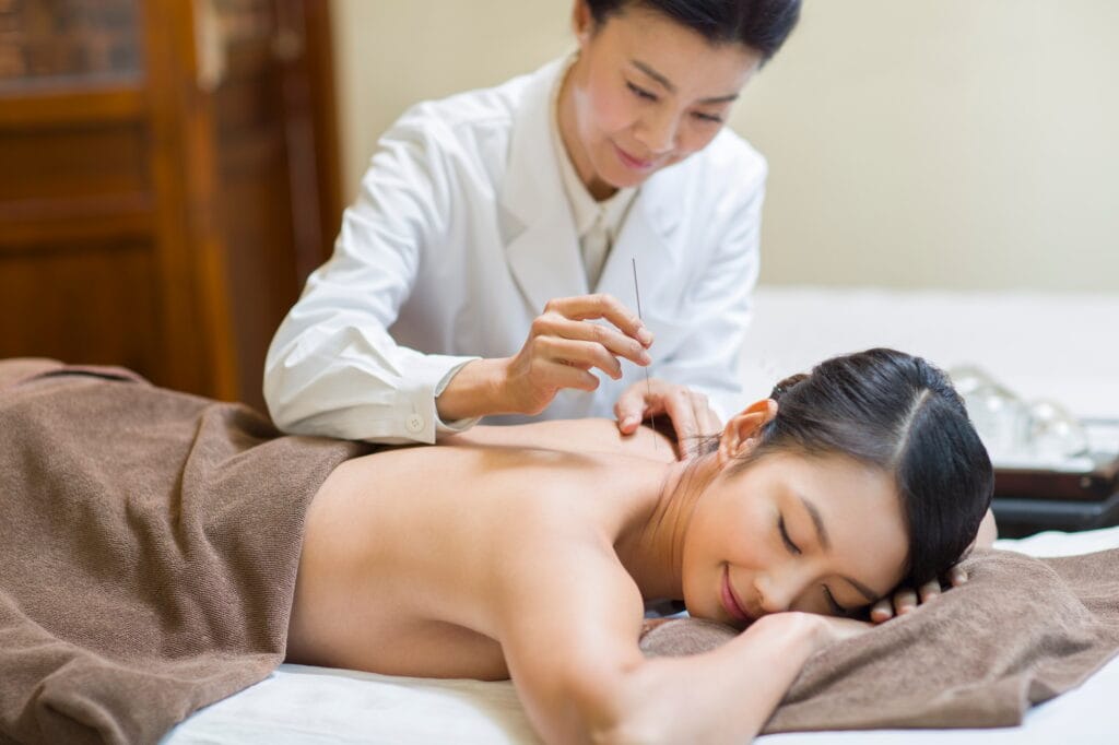 Young woman receiving acupuncture